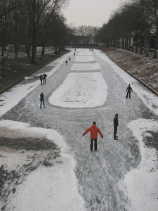 905796 Gezicht over de ijsbaan met enkele schaatsers, op de bevroren Stadsbuitengracht te Utrecht, ter hoogte van de ...